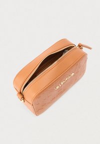 Rektangulær skråveske i tanfarget lær med preget mønster, gullfarget glidelås delvis åpen, og gullfarget "Valentino"-logo på forsiden.