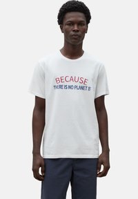 Camiseta de algodón blanca con texto bordado: "PORQUE NO HAY UN PLANETA B" en rojo y azul. Manga corta, cuello redondo.