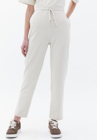 Crèmekleurige joggers gemaakt van zachte stof, met een elastische tailleband met trekkoord, slim fit en zijzakken.