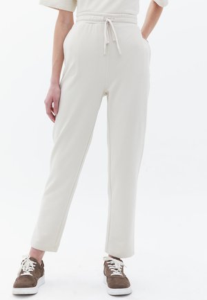 Cremefarvede joggers lavet af blødt stof, med elastisk talje med snor, slim fit og sidelommer.