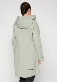 Giacca impermeabile grigio chiaro con cappuccio, con logo sul retro, maniche lunghe e taglio dritto. Include un accento orizzontale all'orlo.