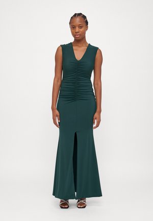 Green sleeveless dress with a V-neck, ruched bodice, and a front slit. Made from smooth fabric, it has a fitted silhouette and flared bottom.
