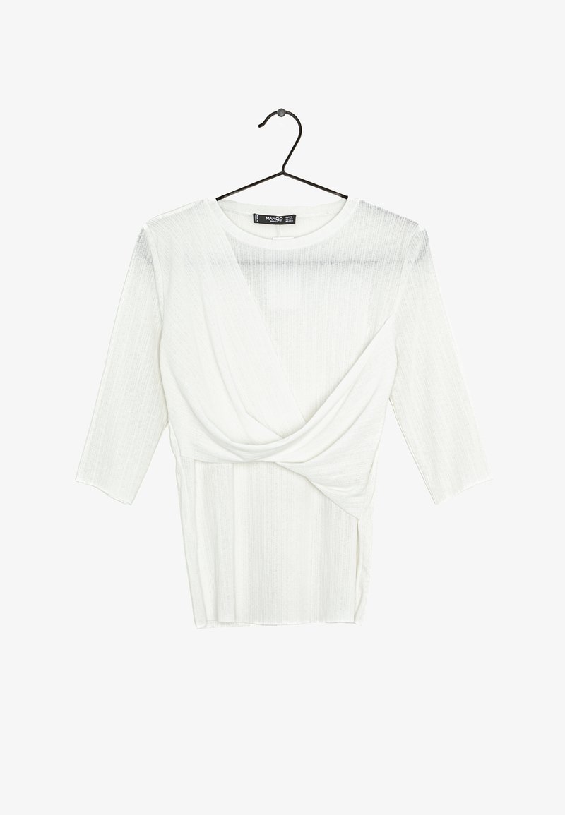 Haut blanc à manches longues en maille côtelée avec détail croisé drapé à l'avant, suspendu à un cintre noir sur fond blanc.