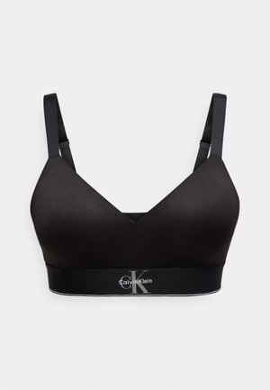 Bralette wireless nero senza cuciture con spalline regolabili e logo Calvin Klein sulla fascia elastica sotto il busto.