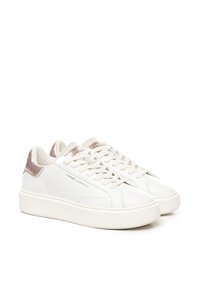 Sneakers bianchi in pelle con accenti in oro rosa sul tallone, lacci piatti e suola in gomma texturizzata. Il nome del marchio è visibile sul lato.