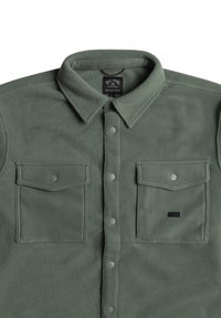 Green fleece button-up shirt featuring a classic collar, two chest pockets with snap closures, and a rectangular brand tag.