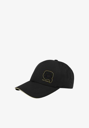 Casquette de baseball noire avec un logo contour doré représentant un visage stylisé portant des lunettes de soleil et le texte "KARL LAGERFELD" sur le panneau avant.