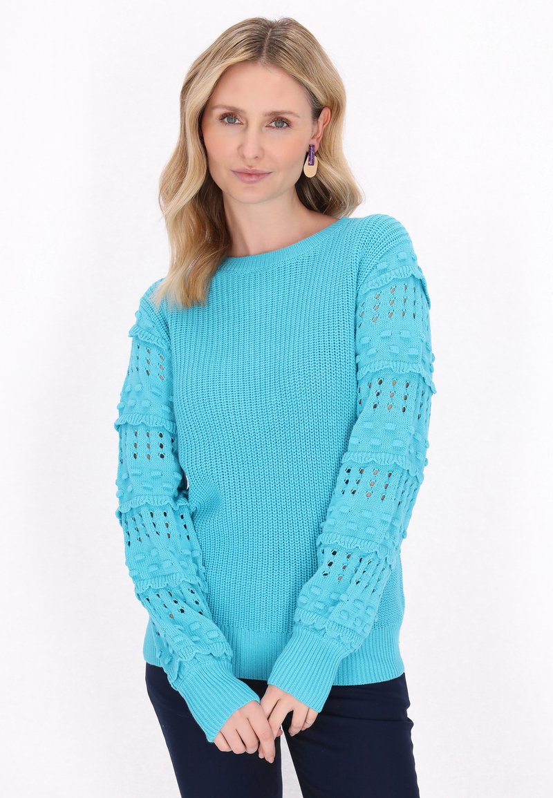Pulover tricotat de culoare turquoise, cu mâneci din dantelă texturată, având un guler și manșete ribbate. Țesătură netedă cu modele deschise pe mâneci.