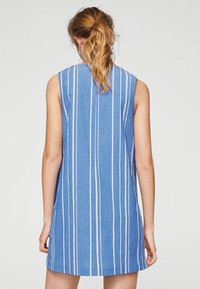 Blaues ärmelloses Kleid mit weißen vertikalen Streifen, mit lockerer Passform und weichem, strukturiertem Stoff, der über dem Oberschenkel endet.