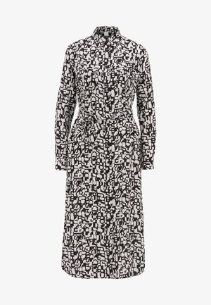 Long-sleeve button-up dress with collar, waist tie, chest pockets, and black and white abstract geometric pattern.