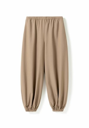 Beige løstsiddende bukser med elastisk talje og indsnørede elastiske manchetter, lagt fladt på en hvid baggrund.