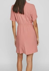 Abito rosa a maniche corte con vita elasticizzata, lunghezza sopra il ginocchio, realizzato in un tessuto leggero, con una vestibilità comoda e un design essenziale.