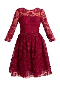 Robe bordeaux longueur genou avec superposition en dentelle florale, manches longues transparentes, corsage ajusté et jupe ample.