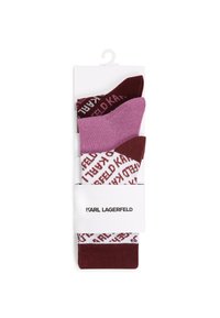 Sett med tre sokker i fargene mørkerød, rosa og hvit med et gjentakende logo-mønster. Mykt strikket materiale, vist på en pappbakgrunn.