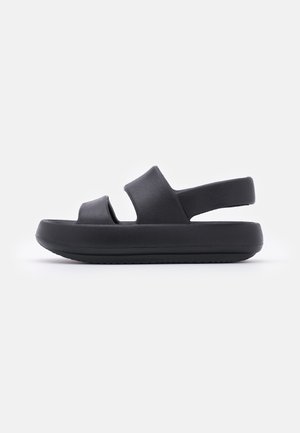 Black sandals with a textured upper, open toe, two wide straps, and a cushioned sole. Design includes a rear heel strap for support.
