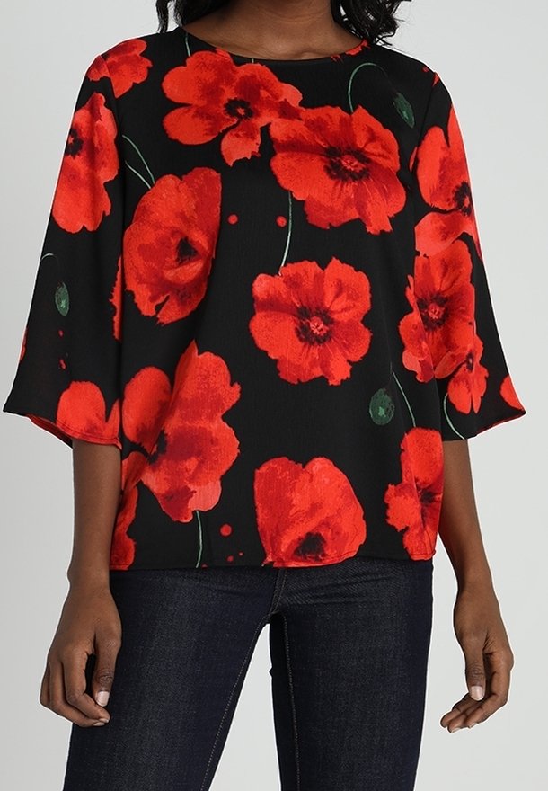 Blouse noire à motif floral rouge, avec des manches cloche courtes et une coupe décontractée. Confectionnée en tissu léger à la texture lisse.