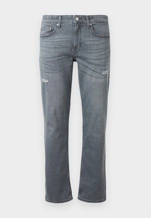 Pilko džinsai su tiesiu kulkšnim dizainu, šiek tiek suplyšimu keliuose ir tradicine penkių kišenių stilistika. Mygtuko uždarymas liestyje.