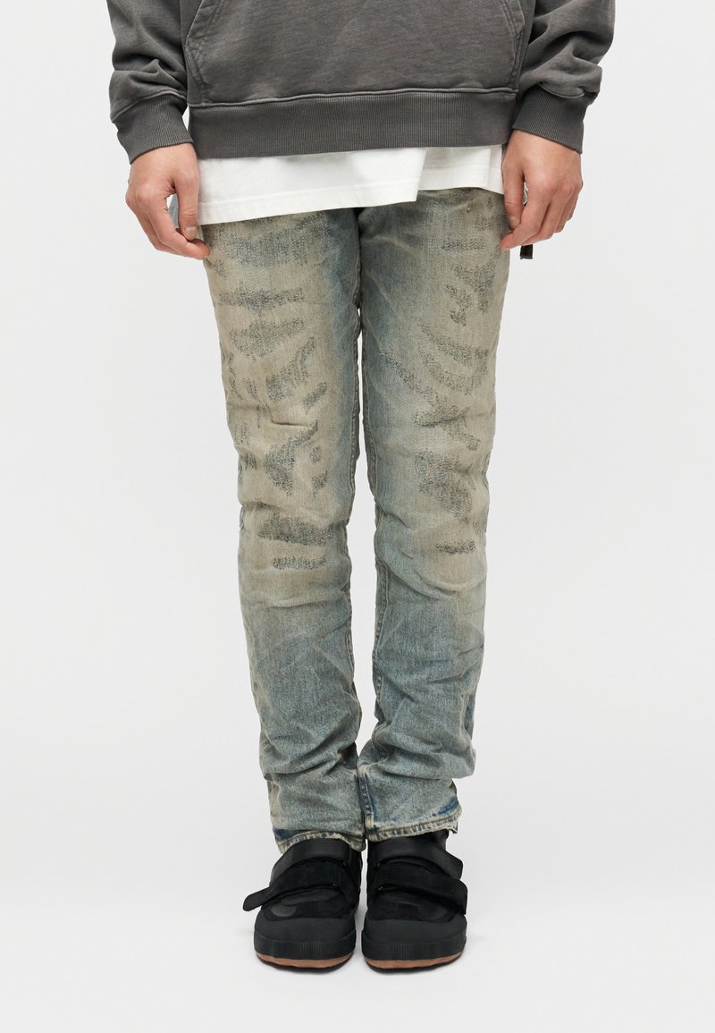 Kahvatu tulehelesinised teksad kulunud tekstuuriga, peene mustriga ja kitsas lõikega. Komplektis mustad jalatsid.