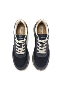 Zapatillas azul marino con parte superior de lona, cordones gris claro, plantilla de corcho y suela de goma marrón. Presenta logotipo y líneas de acento sutiles.