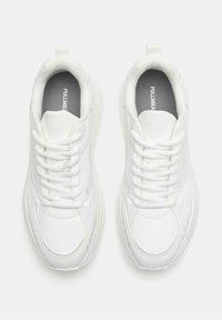 Sneaker bianchi con tomaia in pelle liscia, punta arrotondata, collo imbottito e chiusura con lacci. Suola ergonomica con leggera texture.