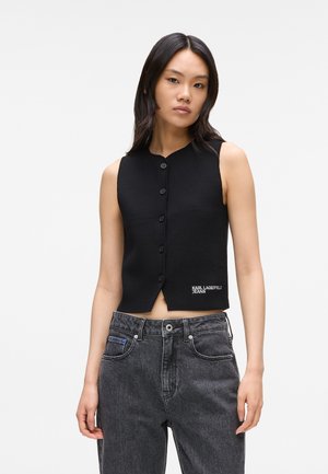 Black cropped sleeveless top featuring a button front, round neckline, and "KARL LAGERFELD JEANS" logo in white, paired with dark denim jeans.