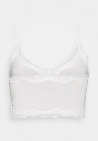 Bralette branca de algodão com alças finas ajustáveis, detalhe em renda ao longo da gola e da bainha, textura suave e design cropped.