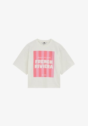 Camiseta blanca de manga corta con rayas verticales rosas y texto blanco que dice "Sérénade des soleils FRENCH RIVIERA" en el frente.