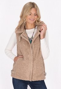 Beige, flauschige Fleece-Weste mit Reißverschluss vorne, Kapuze und zwei Seitentaschen. Mit hellbraunen Akzenten und verstellbaren seitlichen Riemen.