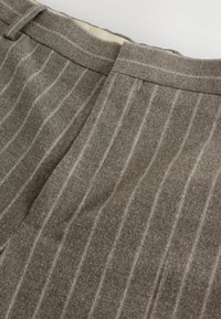Graue Wollhose mit vertikalen Streifen, ausgestattet mit einem flachen Bund und einem strukturierten Stoff. Die Streifen sind heller als die Grundfarbe.