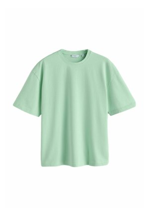 Jasnozielona bawełniana koszulka z krótkim rękawem i okrągłym dekoltem, o luźnym fasonie, z widoczną metką przy szyi.