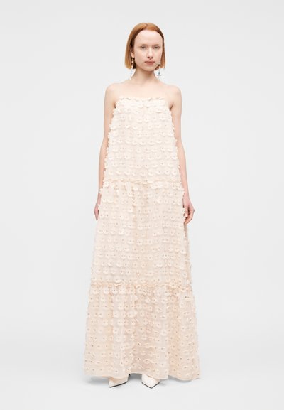 Robe maxi rose clair en tissu texturé, avec des couches, des applications florales et des bretelles fines réglables.