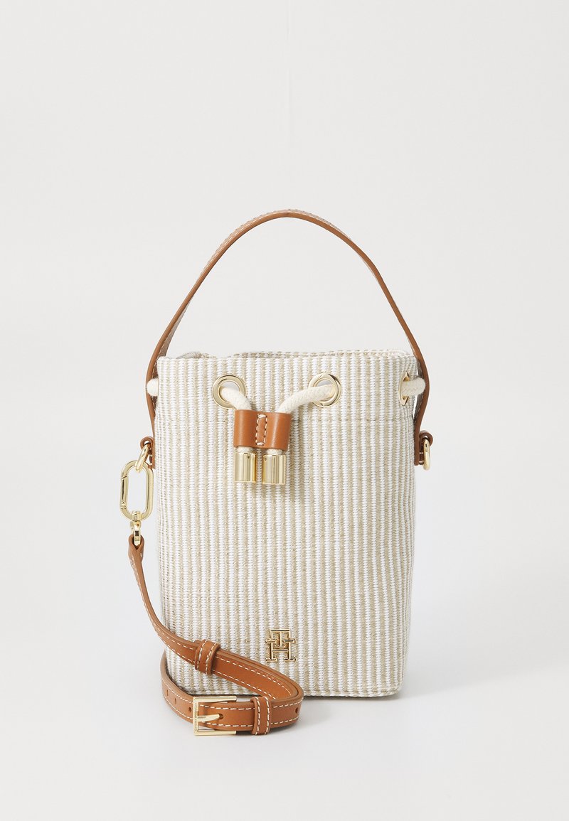 Emmertas in gestructureerde beige stof met tan leren accenten. Voorzien van een trekking sluiting en gouden hardware. Inclusief verstelbare riem.