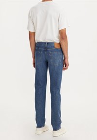 Bleka blå denimjeans med rak passform, som har två bakfickor, en sydd design och en läderlapp på midjebandet.