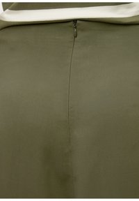 Vêtement vert olive avec une texture lisse, un design ajusté et une fermeture éclair discrète au dos. Apparence minimaliste et élégante.