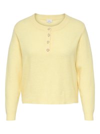 Gul, strikket genser med rund hals, fem hjerteformede knapper foran, og lange ermer. Myk tekstur, kort modell.