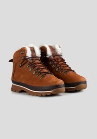 Bruine suède wandelschoenen met witte bontvoering, metalen oogjes en een dikke bruine rubberen zool. Beschikt over een versterkte hiel en een flexibel ontwerp.