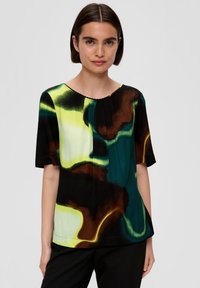 Top à manches courtes avec un motif abstrait multicolore en vert, jaune, noir et marron. Doté d'un col rond et de détails plissés.