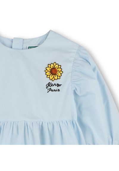 Robe bleu clair avec de longues manches bouffantes, ornée d'une broderie de fleurs et du texte "Glenza Paris" sur la poitrine. Tissu doux et ourlet froncé.