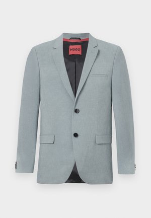 Lichtgrijze blazer van textuurstof, met een zwarte voering, twee voorzakken, notch revers en zwarte knopen. Rode label aan de binnenkant.