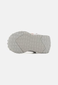 Light gray shoe sole with textured, circular patterns. Features a smooth rectangular section and slight angular detailing on edges.