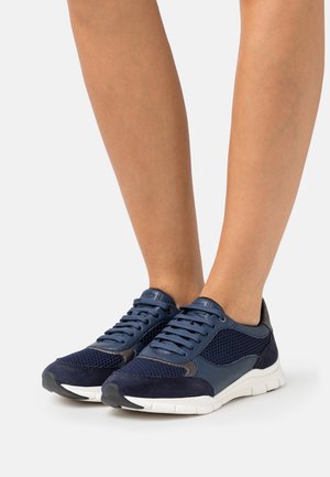 Marineblaue Sportschuhe aus Mesh und Wildleder, runde Zehenform, Schnürdesign und eine weiße Sohle mit strukturierten Akzenten.