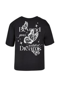 Svart t-skjorte med hvit tekst "Beyond your wildest Dreams" og sommerfuglgrafikk. Korte ermer og rund hals, avslappet passform.