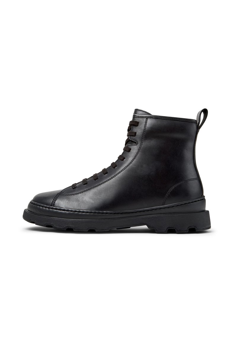 Schwarze Leder Schnürstiefelette mit dickem Gummisohle und Zugschlaufe hinten, seitliche Ansicht auf weißem Hintergrund.