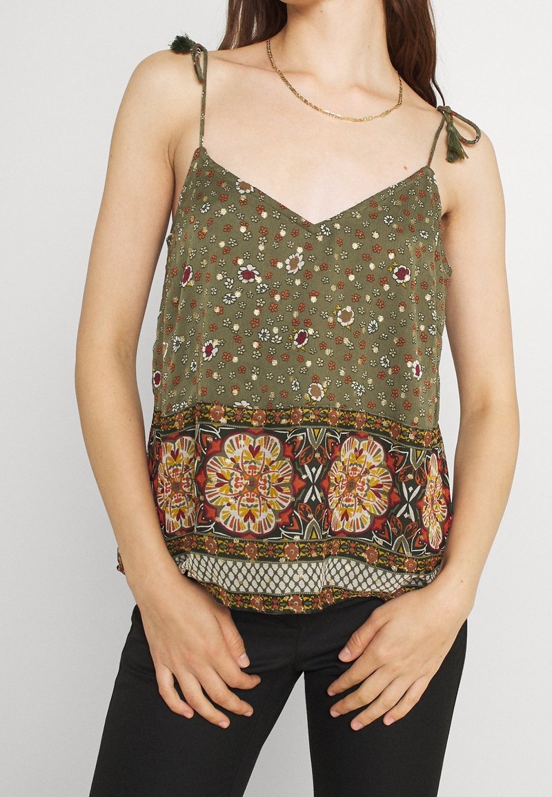 Olivgrön ärmlös topp med blommönster, med spetsdetalj vid nederkanten och färgglada geometriska inslag i botten.