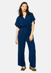 Navy blauwe wikkel jumpsuit met korte mouwen, wijde benen en een strik in de taille. Gemaakt van zachte, gestructureerde stof.