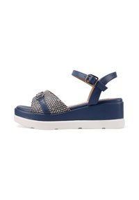 Sandali platform in blu navy e crema con tomaia in tessuto intrecciato, cinturino alla caviglia regolabile e fibbia decorativa sul davanti.