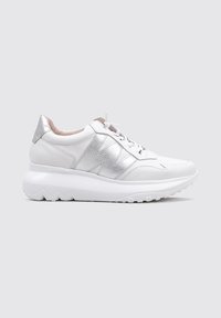 Zapatilla blanca con parte superior de cuero texturizado y acentos plateados. Cuenta con una gruesa suela blanca con un patrón ondulado y un diseño tradicional de cordones.