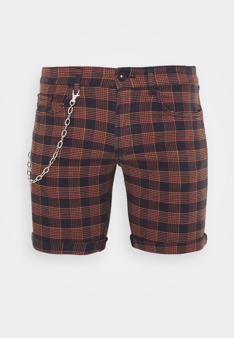 Shorts mi-longs avec motif à carreaux noirs et oranges et une chaîne argentée attachée à la poche avant gauche sur fond blanc.