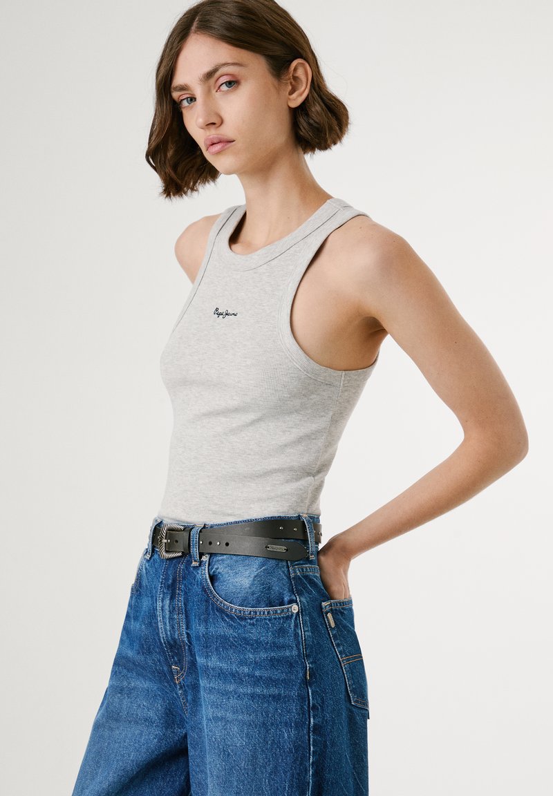 Graues ärmelloses Tanktop aus geripptem Stoff, mit rundem Ausschnitt und besticktem Logo. Kombiniert mit hochtaillierten blauen Jeans aus Denim und einem schwarzen Gurt.
