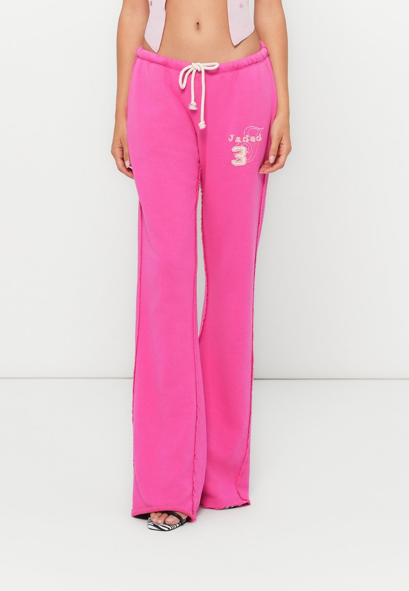 Pink flared sweatpants in cotton blend, featuring an elastic waistband with drawstring, graphic embellishment, and side slits.